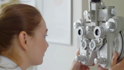 Optometrist Using Phoropter to Check Eyesight of Patient Video stock 105568677