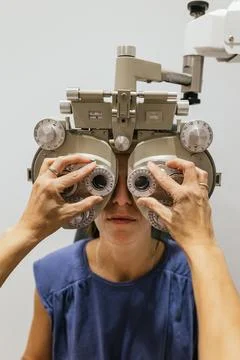 Optometrist using phoropter for eyesight testing Stock Photos
