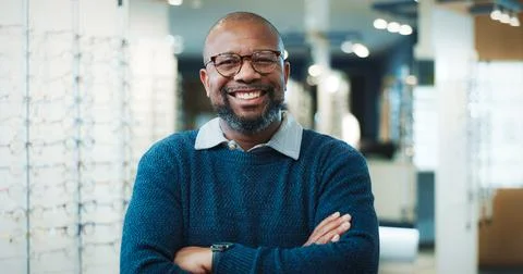 Optometry, portrait or black man in store with arms crossed, eyewear expert or Stock Photos