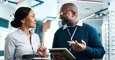 Optometry, tablet and discussion with people in store for consulting, glasses Stock Photos