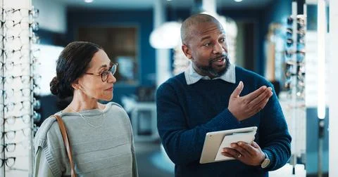Optometry, tablet and retail with people in store for consulting, glasses advice Stock Photos