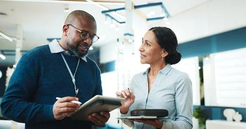 Optometry, tablet and talk with people in store for consulting, glasses advice Stock Photos