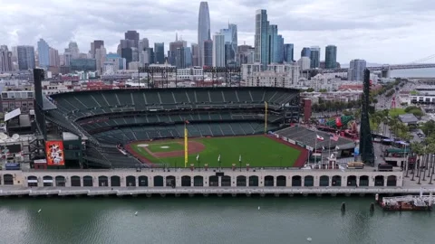 Oracle Park's empty green baseball diamond sits beside calm bay waterfront Stock Footage 340042447