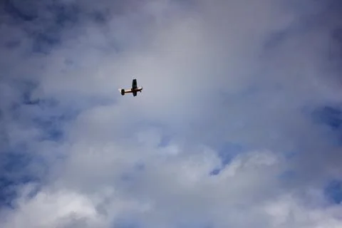 Orange airplane soaring through cloudy mexican skies Stock Photos