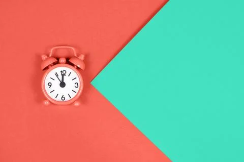 Orange alarm clock on colored background. Stock-Fotos