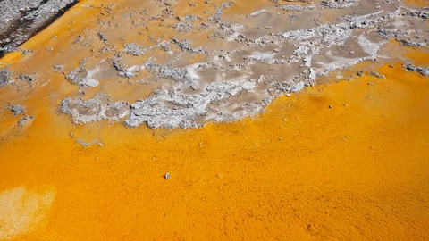 Orange Algae and Bacterial Pool With Hot Water Flowing Over It (Yellowstone) Stock Footage 128032843