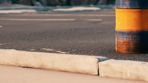 Orange and blue barrel sits on the road near curb during daytime Stock Footage 344160814