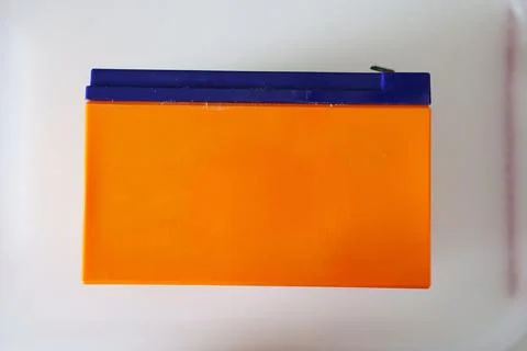 Orange and blue plastic container on a white surface for storage Stock Photos