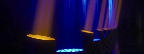 Orange and blue rays of spotlights illuminating curtain on stage in haze Stock Footage 250006607