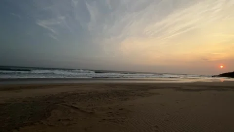 Orange and Blue Sky Sunset Over Ocean, Waves on Sandy Beach, Wide Shot Stock Footage 324771620