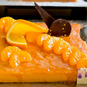 Orange and a piece of orange cake with chocolate topping - finger food Stock Photos