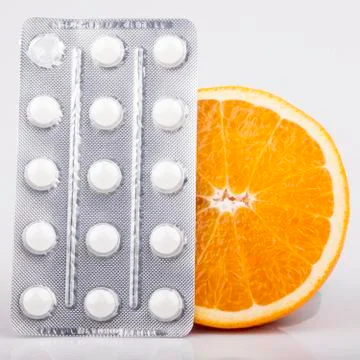 Orange and pills on white Stock Photos