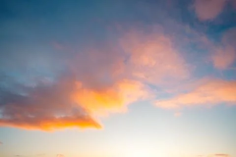 Orange and pink sunset clouds glowing across a blue winter sky above Senja,.. Stock Photos