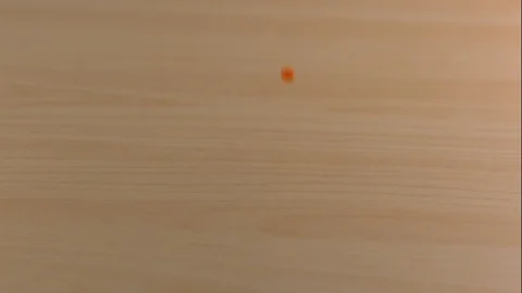 Orange and White Candy Falls on Wooden Table in Slow Motion Stock Footage 85533480