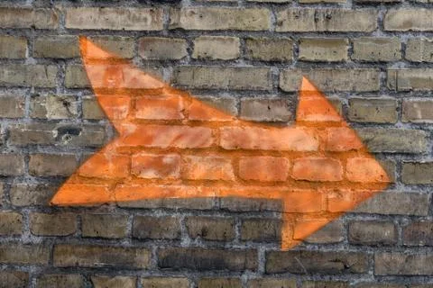 Orange arrow on the wall Stock Photos