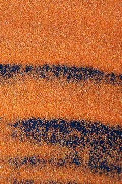 Orange artificial sand on black table for background Stock Photos