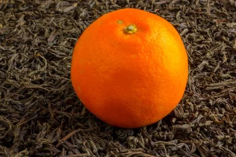 Orange is on the background of black tea Stock Photos