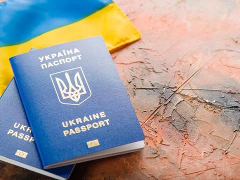 On an orange background, the state Ukrainian flag and two Ukrainian biometric Stock Photos