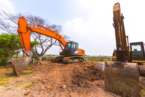 The orange backhoe is on the ground. Stock Photos