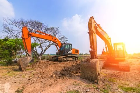 The orange backhoe is on the ground. Stock Photos