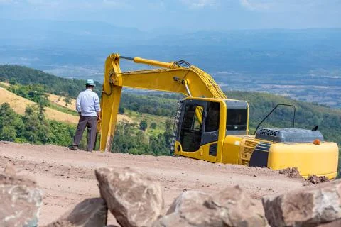 The orange backhoe is on the mountain. Stock Photos