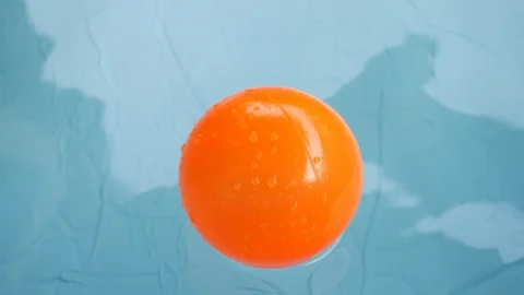 Orange ball floating on clean water of blue swimming pool Stock Footage 93109002