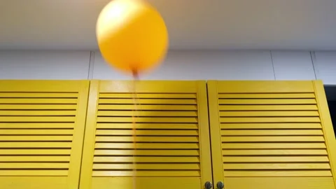 Orange balloon rises to the ceiling in the room Stock Footage 170825097