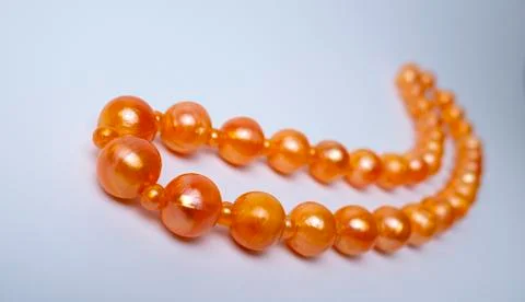 Orange beads on a white background Stock Photos
