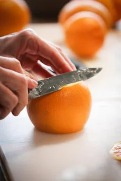 Orange being sliced on a clean table Stock Photos