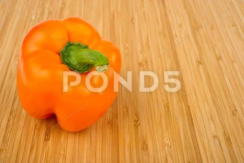 Orange bell pepper on cutting board Stock Photos
