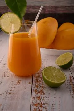 Orange beverage macro with lime slice on white vintage wooden desk Stock-Fotos