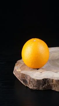 An orange on a black table Stock Photos