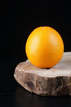 An orange on a black table Stock Photos