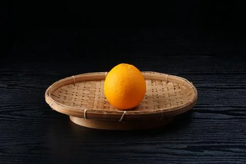 An orange on a black table Stock Photos