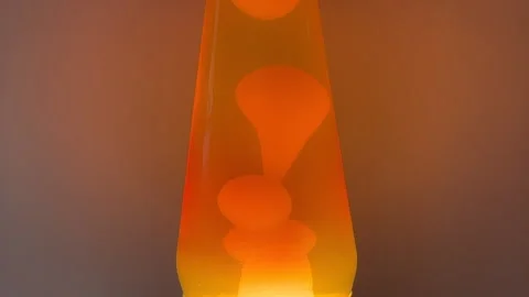 Orange blobs of liquid moving in a novelty motion lamp Stock Footage 328880885