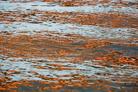 Orange blue white reflection on surface water with waves Stock-Fotos