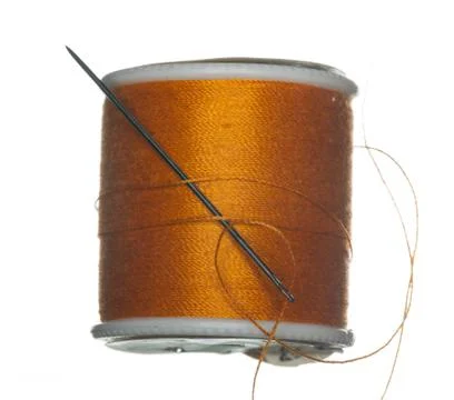 Orange bobbin of thread with needle Stock Photos