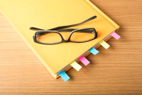 Orange book with sticky note Stock Photos