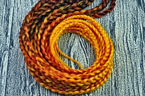 Orange braids on a white background at close range Stock Photos