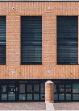 Orange brick building with three large windows. Fotos de archivo