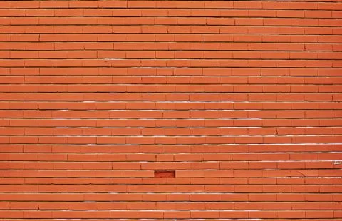 Orange brick wall background with a missing brick Stock Photos