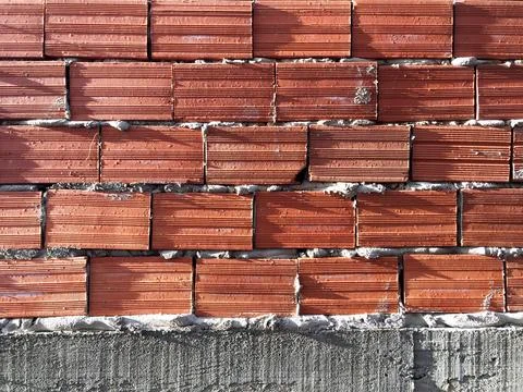 Orange brick wall of a construction in progress for photographic background.  Stock Photos