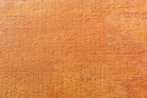 Orange bricks wall texture background. Structure of small stones wallpaper Stock Photos