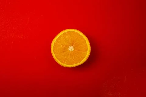 Orange on a bright red background Stock Photos