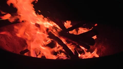 Orange campfire flames swirling in a pit, at night. Stock Footage 274931635