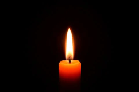Orange candle burning on a black background Stock Photos