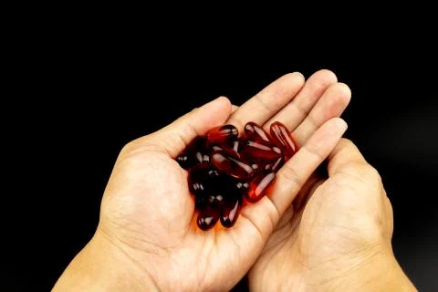 Orange capsules on hand Stock Photos