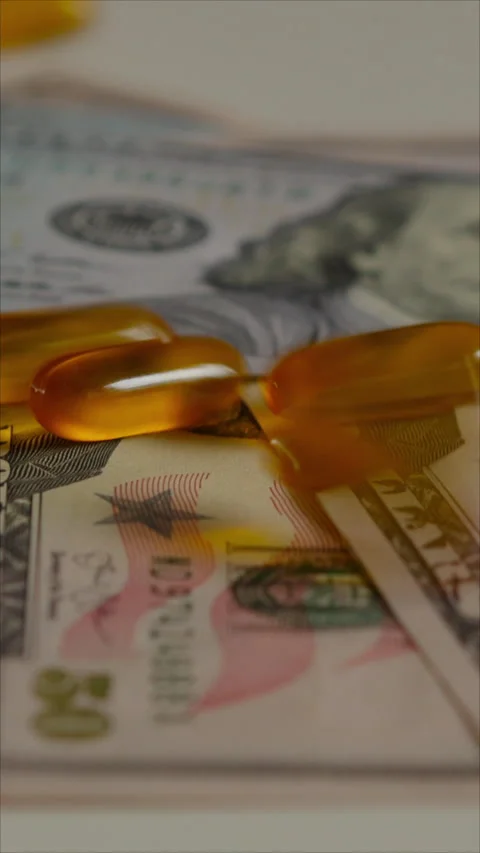 Orange Capsules On Us Dollar Bills Financial Concept. Vertical. Stock Footage 285236592