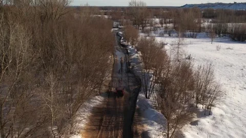 An orange car drives quickly through puddles through the forest, view from a qua Stock Footage 280460235