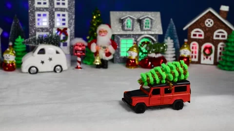 An orange car moves against the backdrop of a Christmas village Stock Footage 308569428